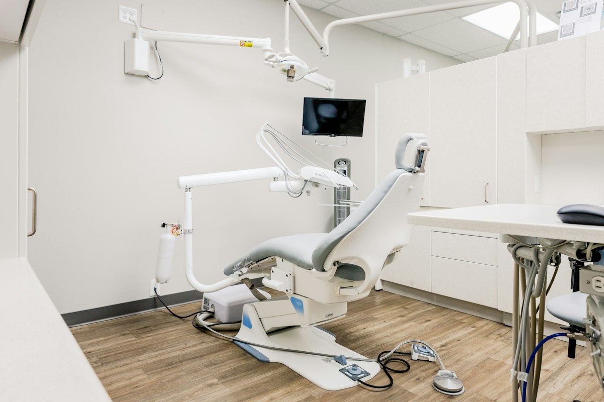 Consultorio odontológico limpio con sillón gris y luz de trabajo